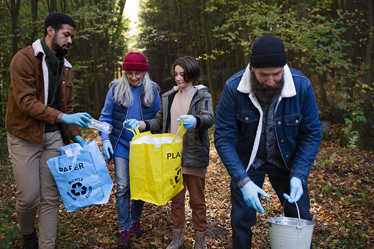 Diverse group of volunteers clean up forest.