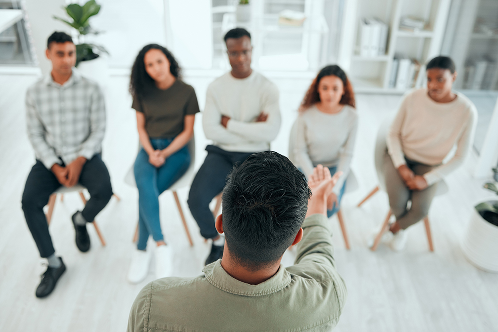 Man talking by himself in front of his peer support group.